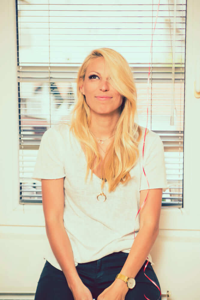 A sugar baby with golden hair, smiling in a white T-shirt